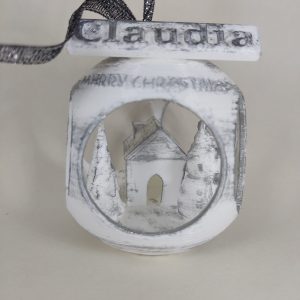 Bola de Navidad con árbol, muñeco de nieve y casa.